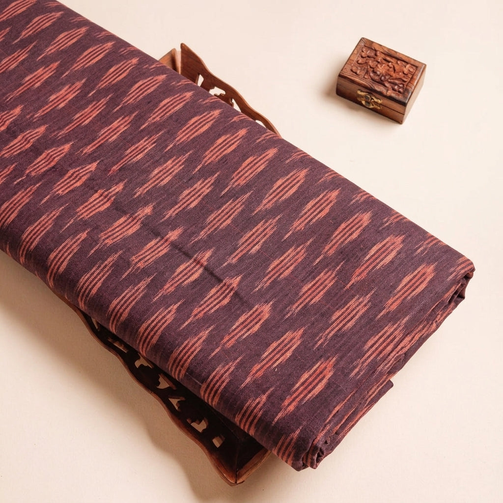 Ikat Maroon Ikat Cotton Fabric on a wooden tray