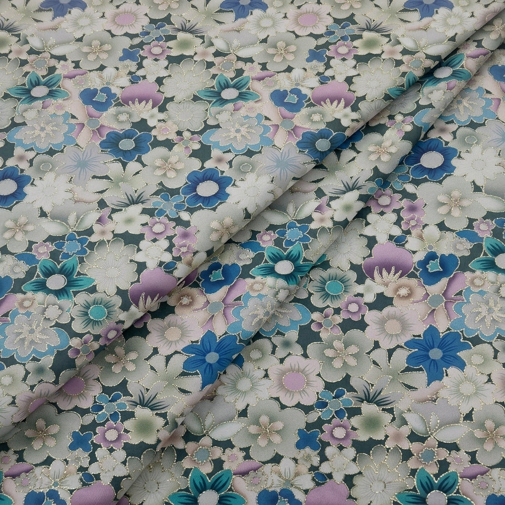 A close-up of a floral fabric with a dense pattern of white, blue, pink, and teal flowers on a dark gray-green background, draped with soft folds.