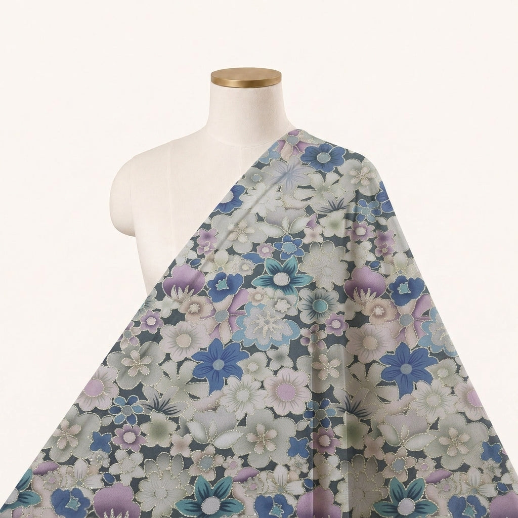 A floral patterned fabric draped over a cream-colored dress form mannequin against a plain off-white background. The fabric features a dense pattern of blue, purple, pink, and white flowers with green leaves on a muted grayish-blue background.