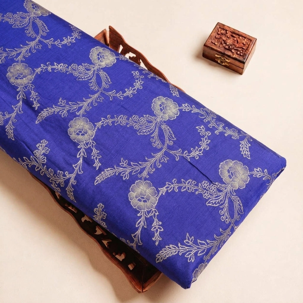 Folded Royal Blue Floral Viscose Organza Fabric Highlighting Zari and Texture