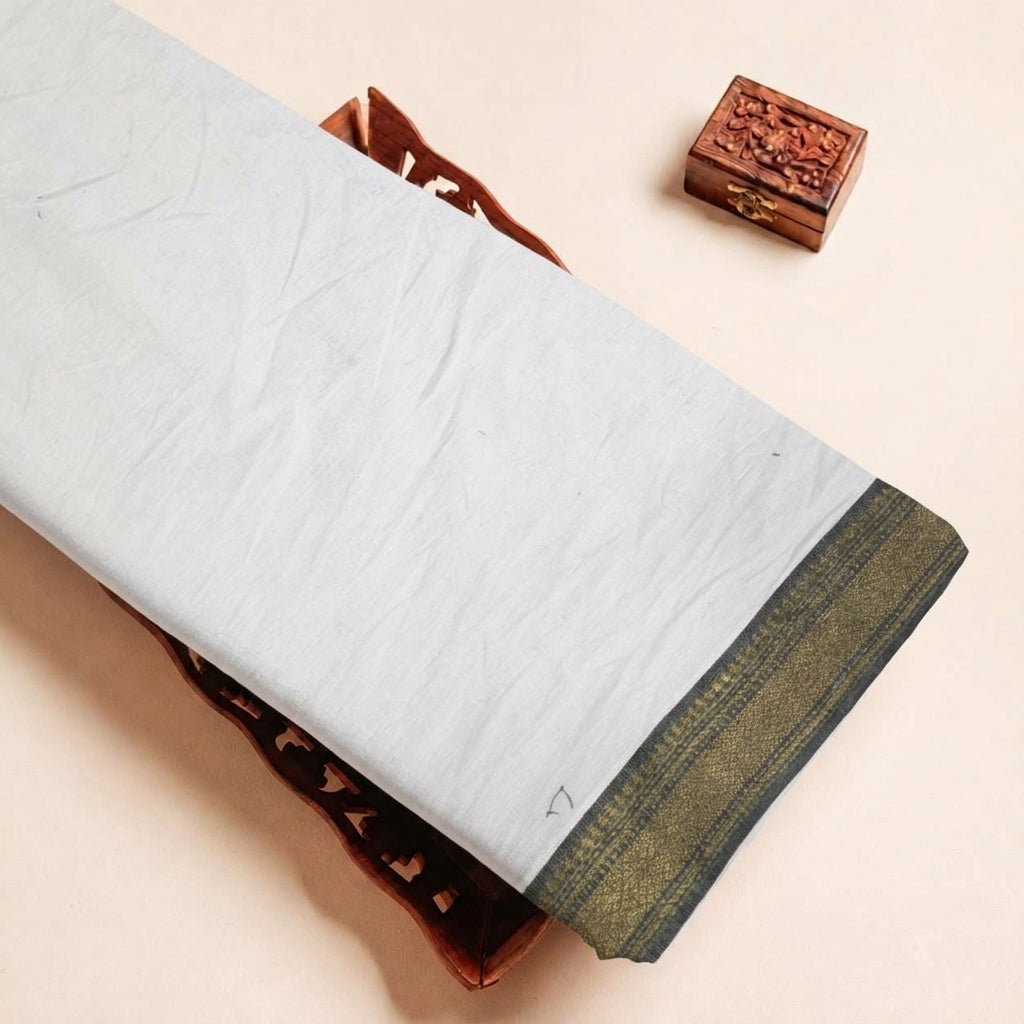 Folded White Zari Border Cotton Fabric Highlighting Zari and Texture