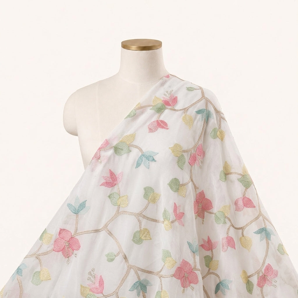 A white sheer fabric drape with a delicate pastel floral vine pattern, displayed on a cream-colored mannequin torso against a clean white background.