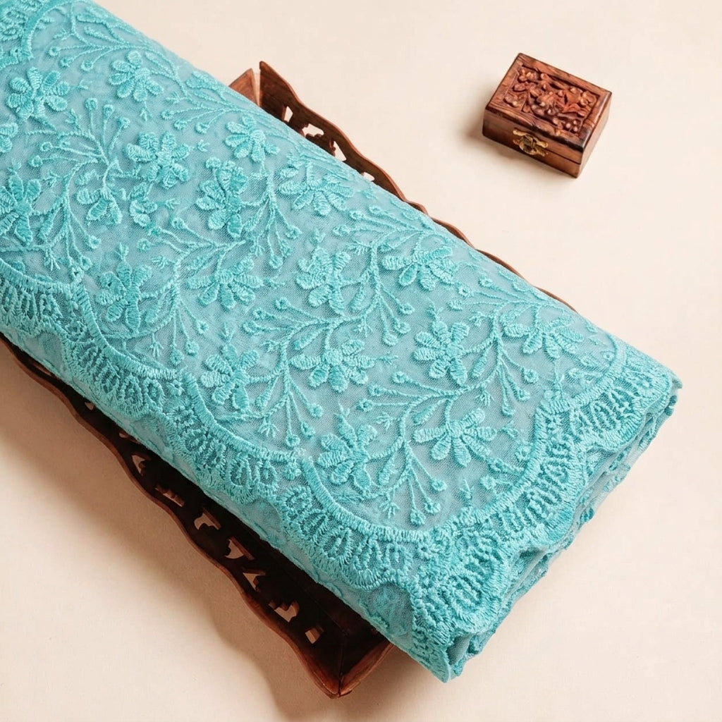 Folded Green Embroidery Lace Fabric Highlighting Floral and Texture