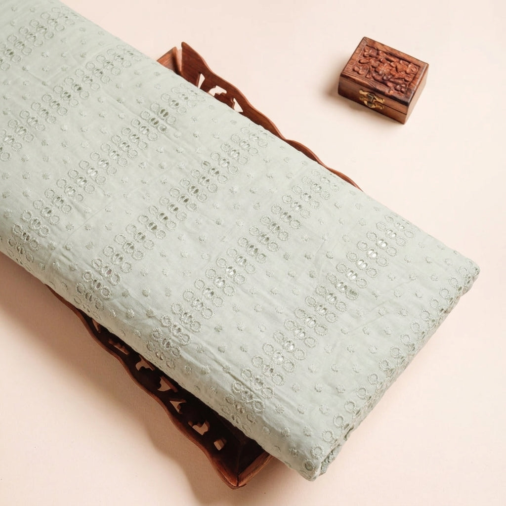 Cutwork Pastel Green Cutwork Cotton Fabric on a wooden tray