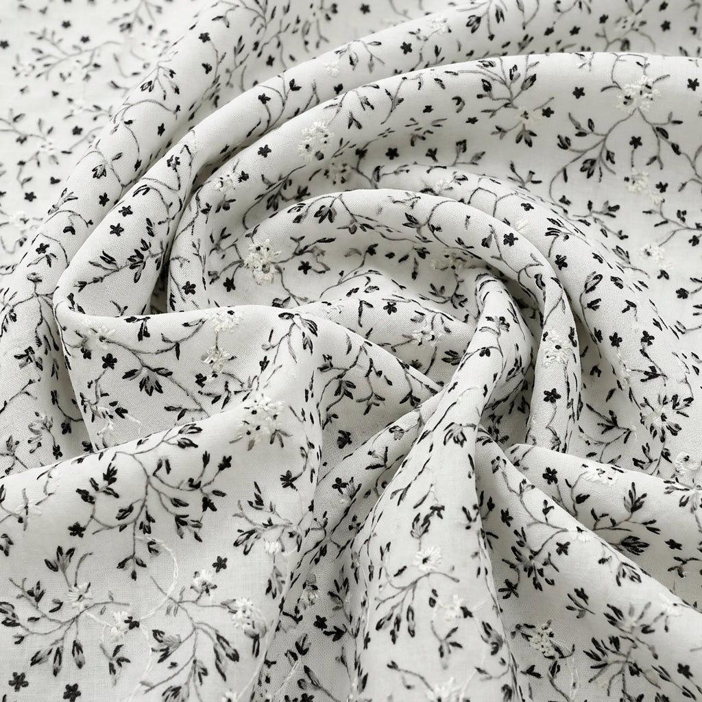 Black Cream Embroidery Cotton Fabric, swirled to show the drape